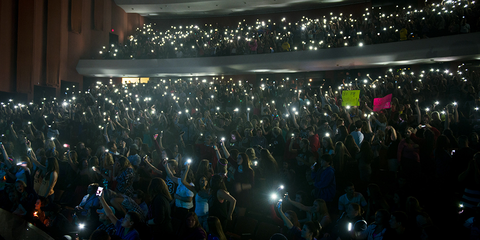 Braden Auditorium lit with phone lights while a concert goes on.